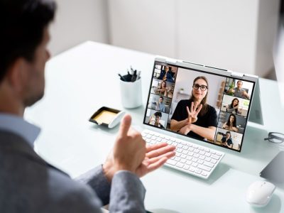 Due persone comunicano in lingua dei segni durante una videoconferenza, mentre gli altri partecipanti seguono.