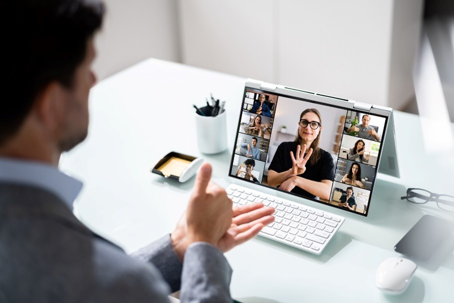 Due persone comunicano in lingua dei segni durante una videoconferenza, mentre gli altri partecipanti seguono.
